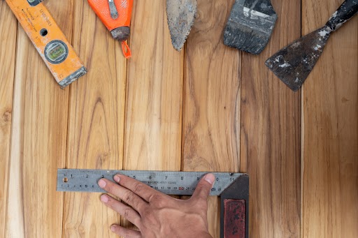 Interior designer reviewing wooden flooring samples, highlighting common mistakes in selection, installation, and maintenance of wood floors.